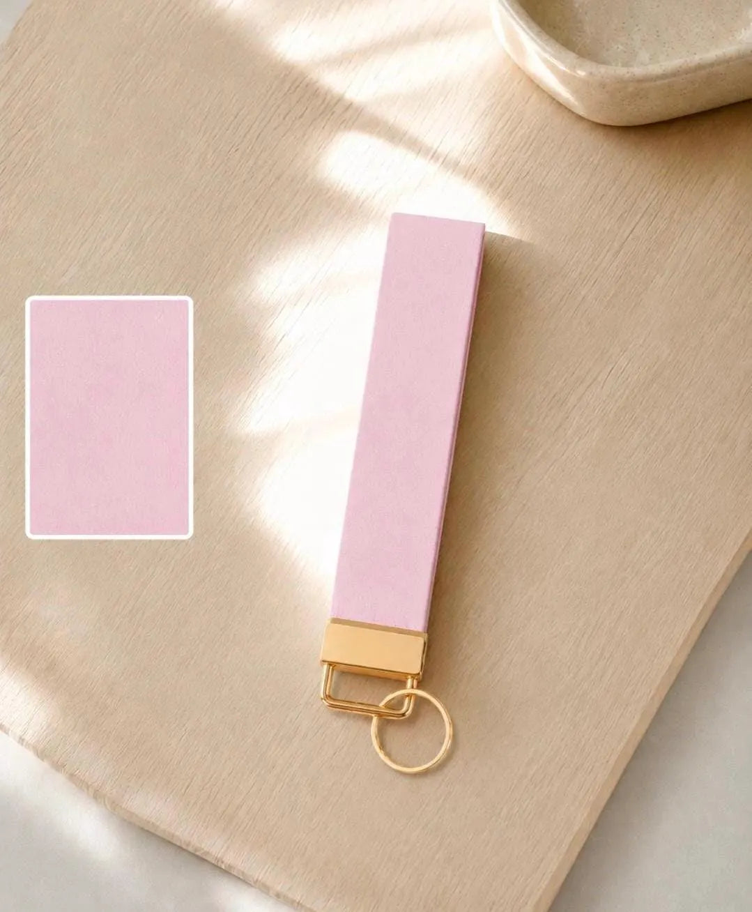 Baby pink wristlet keychain flat lay with color swatch on wood surface — Sundazed Petal Pink Wristlet