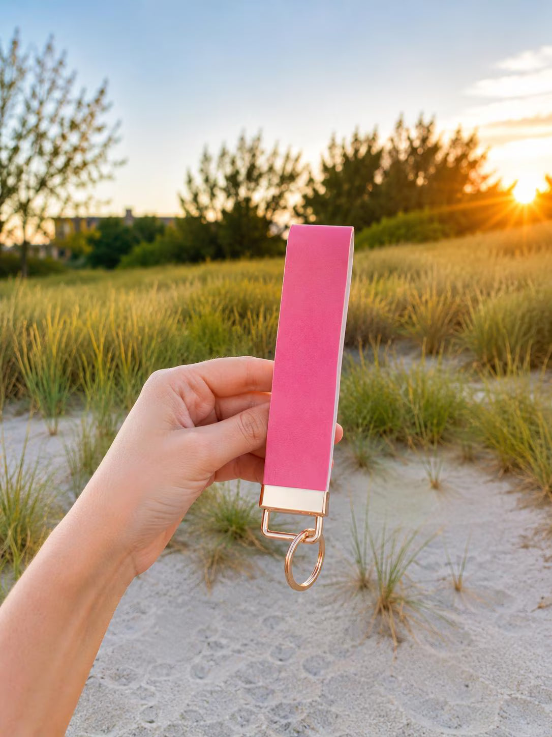 Hot pink faux leather wristlet keychain held at sunset on beach dunes — Petal Pink Wristlet by Sundazed