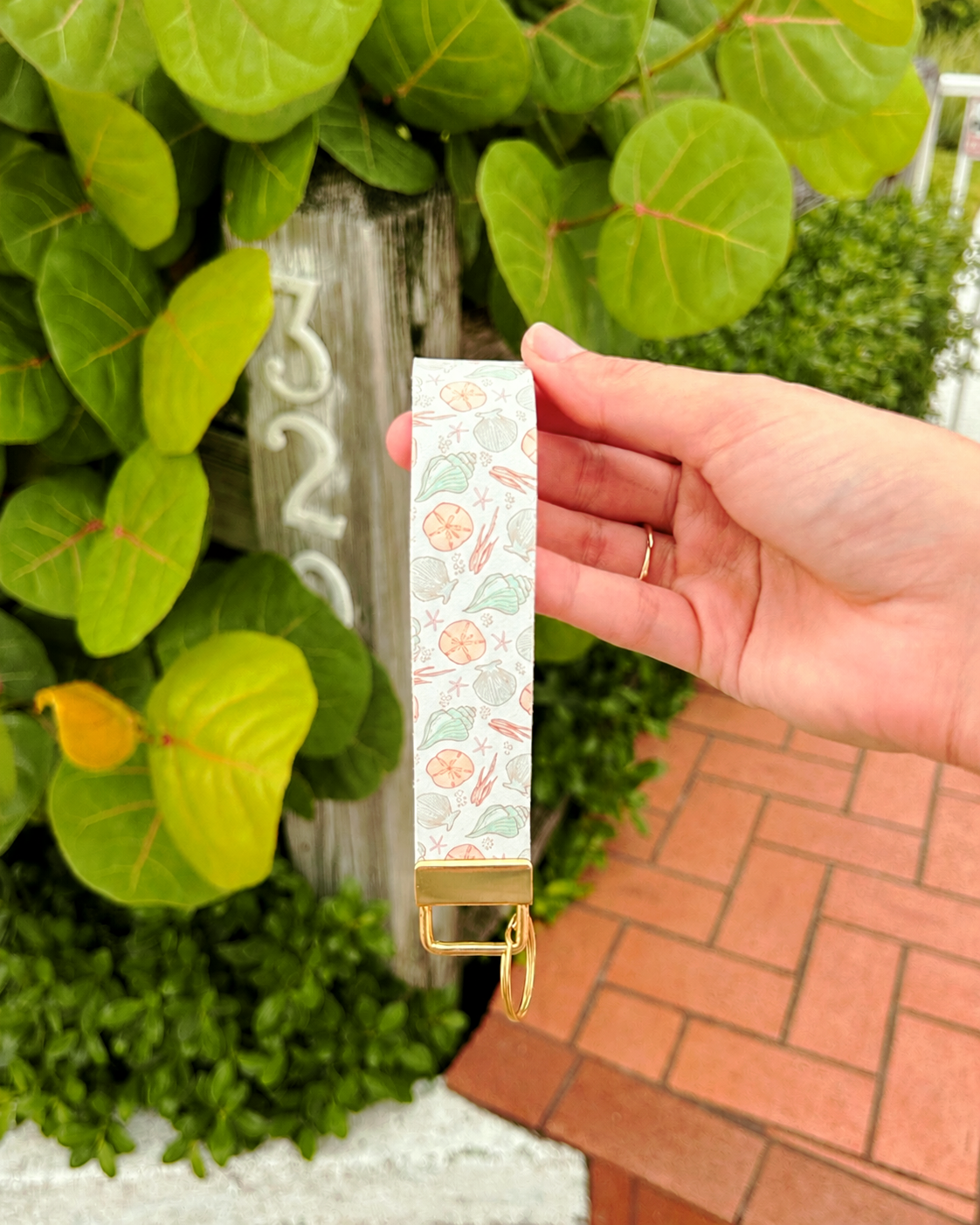 Meet Me in the Sand Wristlet with seashell print and gold hardware