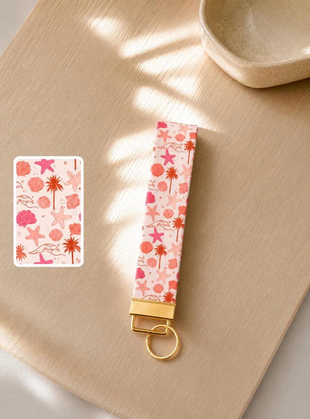 Pink and orange starfish and seashell print faux leather wristlet keychain by Sundazed — Beach Babe Wristlet flat lay