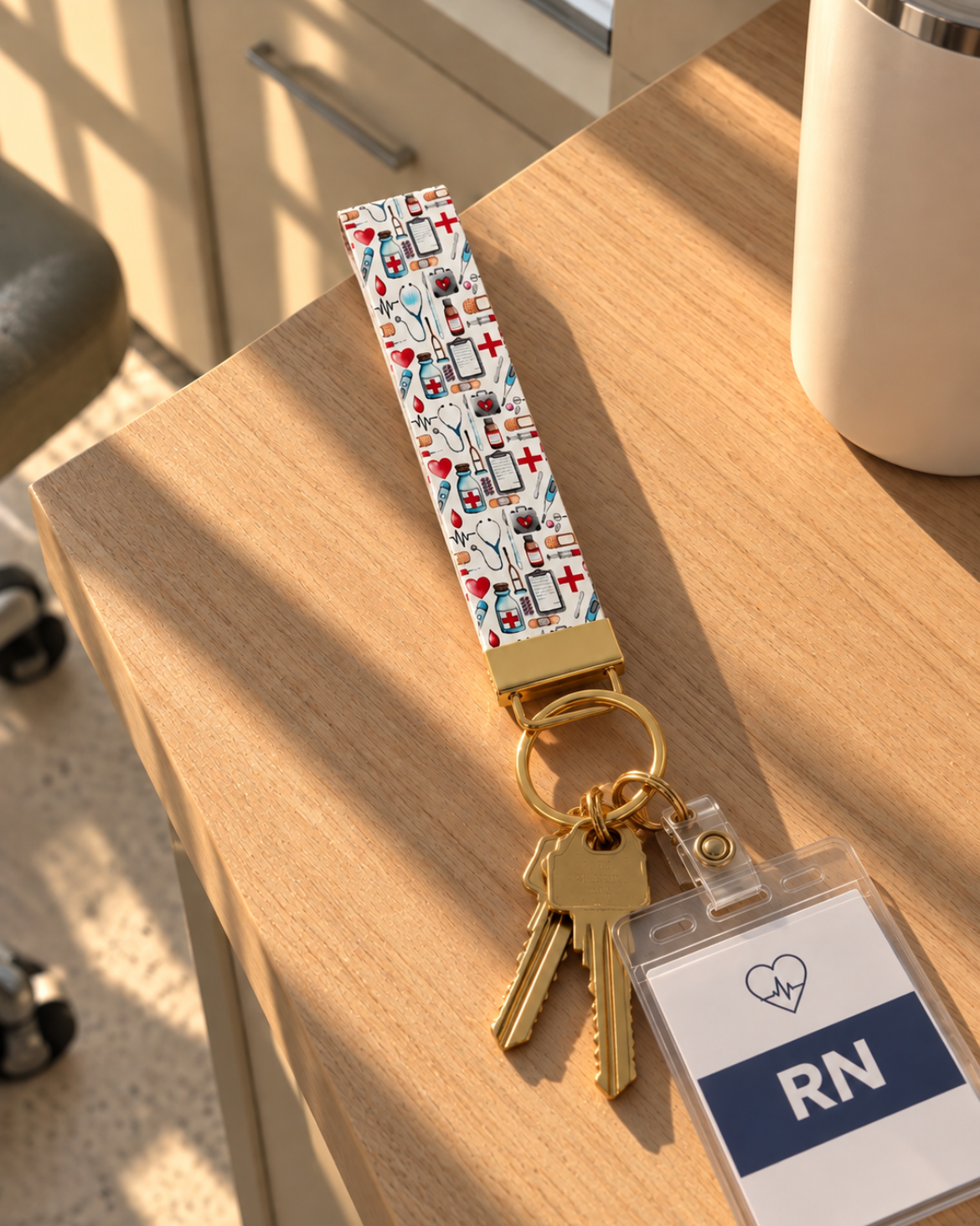 A patterned medical nurse keychain with gold-toned keys and a clear ID badge holder, placed on a wooden table in a real indoor setting. The keychain strap has a multicolor graphic  medical prints.